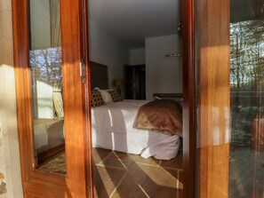 A bedroom with a bed, a window, and a view of trees.