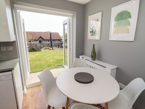 A modern kitchen with a white countertop, a built-in dishwasher, and a sliding glass door leading to a backyard. - 26 Field Court (Wooler)