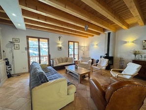 A spacious living room with a high wooden ceiling, a fireplace, and a balcony with a view. - 1st floor, terrace, fireplace or stove, ski locker, 165m², Vars (Vars)