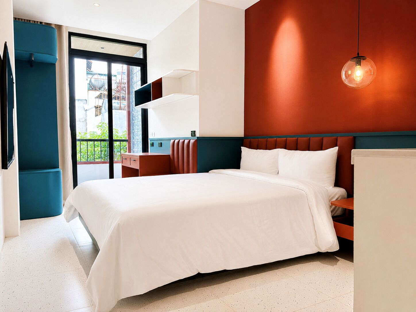 Une chambre d’hôtel moderne, dotée d’un grand lit, d’un bureau et offrant une vue sur l’extérieur.