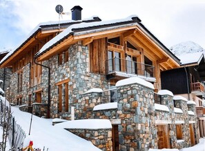 A stone and wood chalet with a balcony, set in a snowy mountainous area. - Chalet, Ground floor, balcony, fireplace or stove, tv, ski locker, 380m², Saint Martin de Belleville (Saint-Martin-de-Belleville)