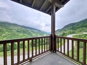A balcony with a view of a winding road through a valley. - 3rd floor, swimming pool, balcony, tv, ski locker, 50m², Les Menuires (Les Menuires)