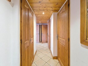 Ein Korridor mit Holztüren und Fliesenboden.