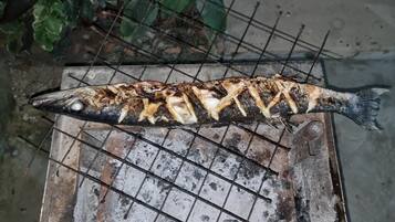 Un pescado a la parrilla sobre una rejilla de metal.