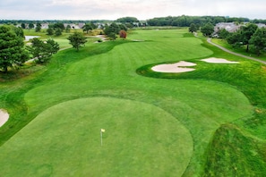 A golf course with sand bunkers, trees, and a flag. - Huge, Luxurious, Steps to the Golf Course, Pools, Gym, Beach Shuttle, 1 Free Round of Golf Per Day (Ocean View)