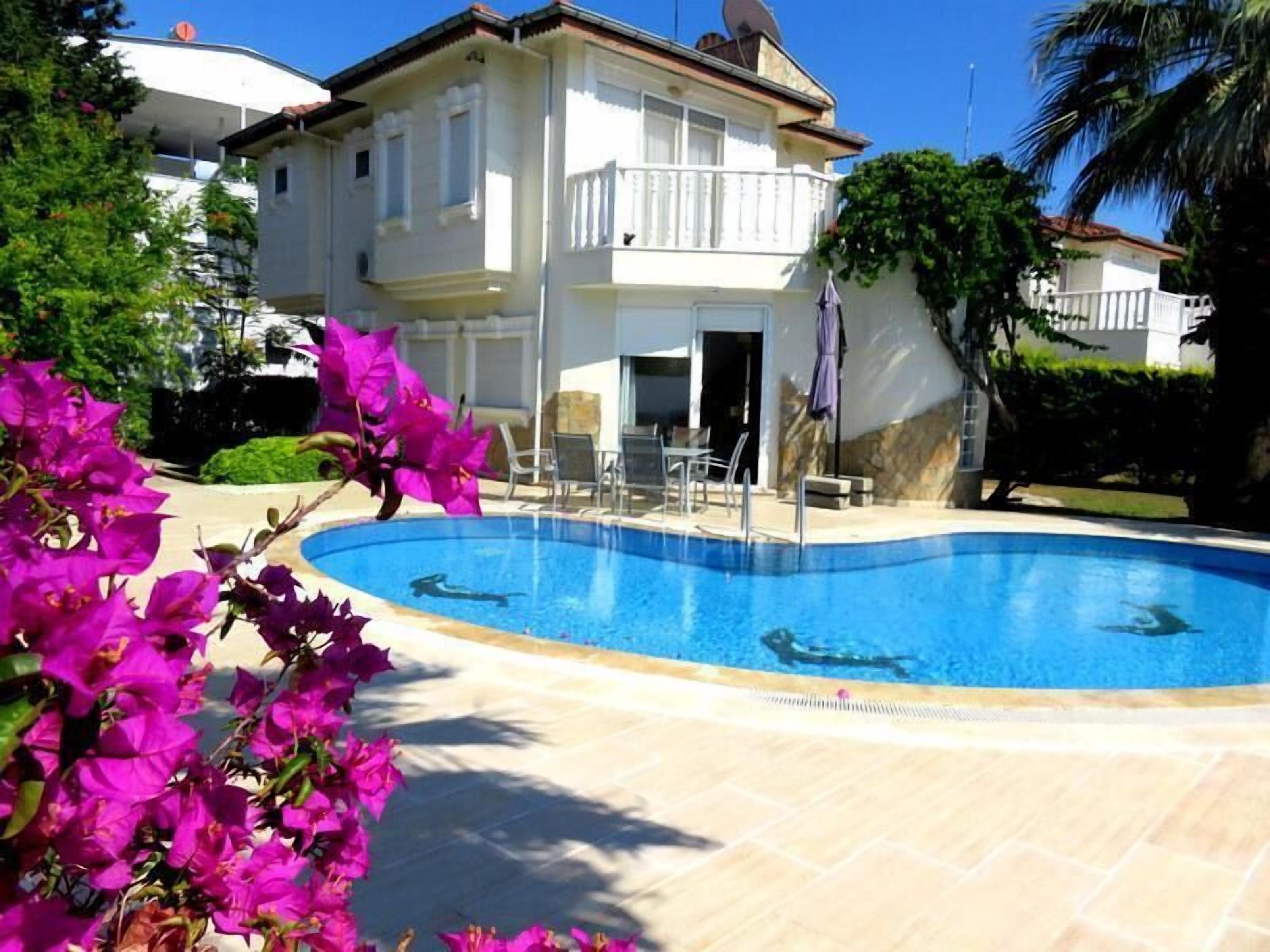 A swimming pool with a white building in the background.