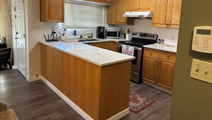 A kitchen with wooden cabinets, a central island, a microwave, a stove, and a built-in oven.