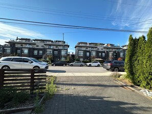 A residential area with modern apartment buildings, a paved driveway, and parked cars. - few minutes walk to skytrain or transit.
6 minutes  to Metro town mall in a car (Burnaby)