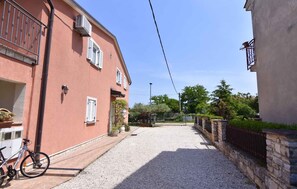 A narrow street with buildings on either side, a bicycle, and a gravel path. - Lovely Accommodation With Private Garden (Umag)