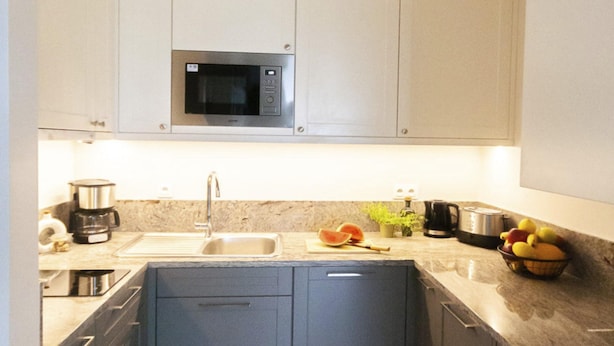 A modern kitchen with a built-in microwave, a sink, and various appliances. - Aesthetic Couples Hideaway by the Coast (Dziwnów)