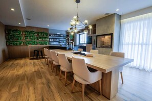 Una cocina moderna con una isla central, suelo de madera y un adorno verde en la pared.