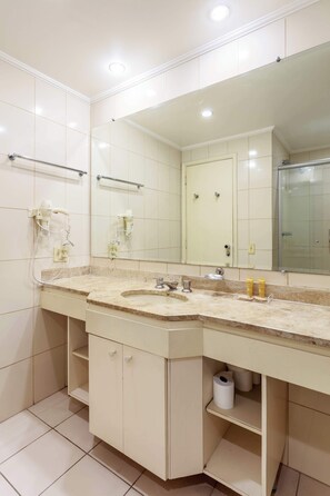 A bathroom with a large mirror, a sink, a toilet, and a shower. - Flat completo a 500m da Faria Lima | RI233 (Itaim Bibi)