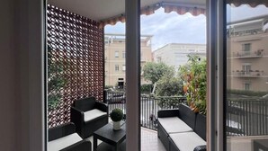 A balcony with wicker furniture, a small table, and a potted plant. - Terracina Central Rooms (Terracina)