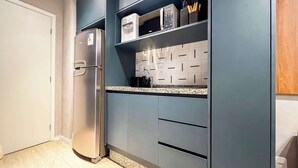 A modern kitchen with a built-in microwave, a refrigerator, and a coffee machine. - #MY606 | Cyclinn Pinheiros (Pinheiros)