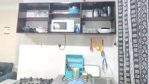 A kitchen with a microwave, stove, and various utensils. - Modern Airport Studio Near SGR & Moi Airport (Mombasa)