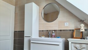 A bathroom with a white vanity, a mirror, and a towel rack. - Family home near Chambord (Mont-près-Chambord)