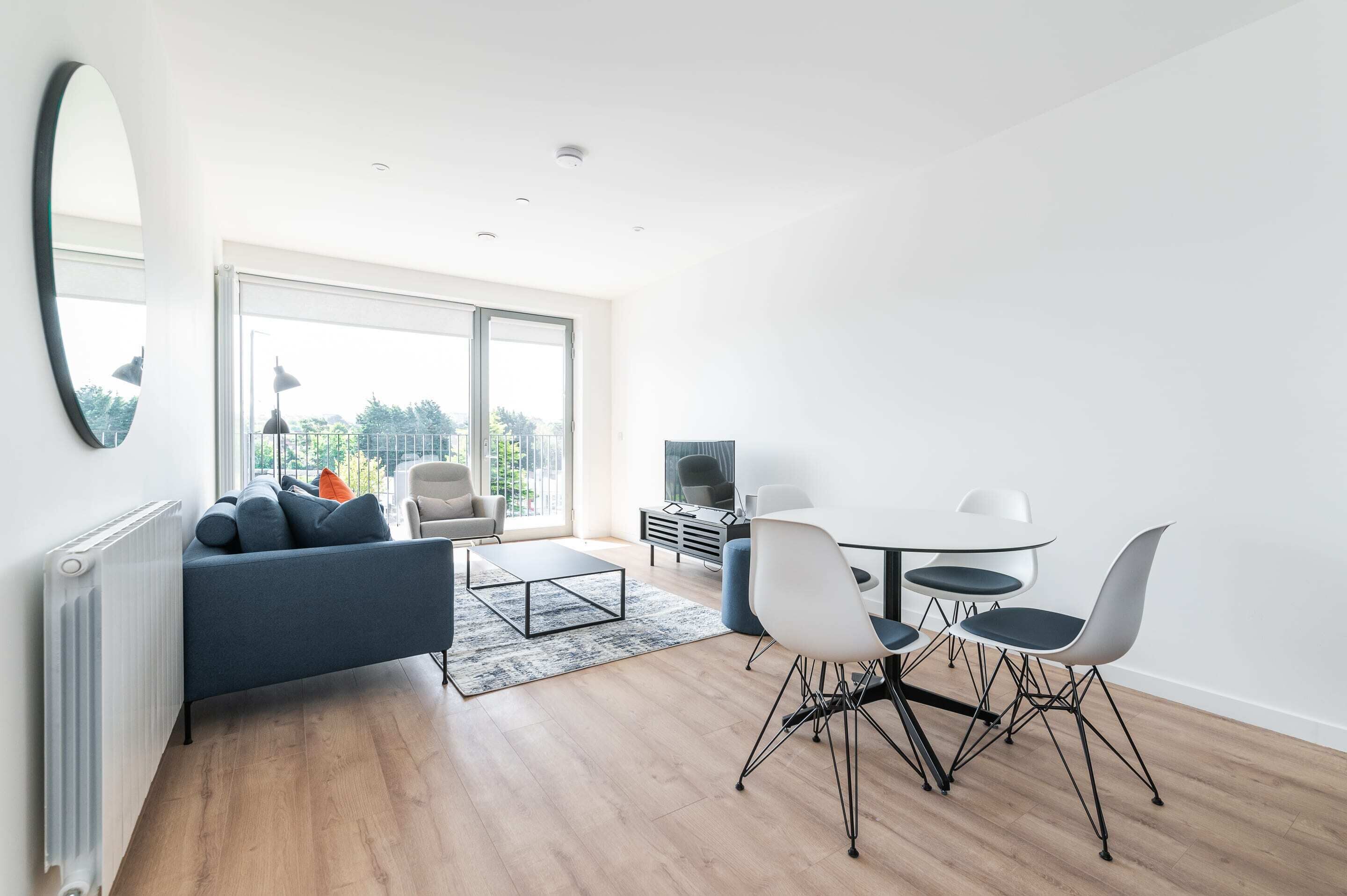 Un salon moderne comprenant un canapé, une table basse, une table à manger et des chaises.