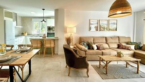 A modern living room with a sofa, coffee table, and dining area.