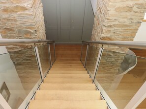 A staircase with glass railings and stone walls. - Lower Velwell Barn (Totnes)