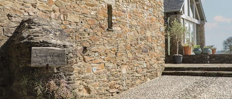 Ein Steinhaus mit einem Schild, auf dem 'Lower Velvel Barns' steht.