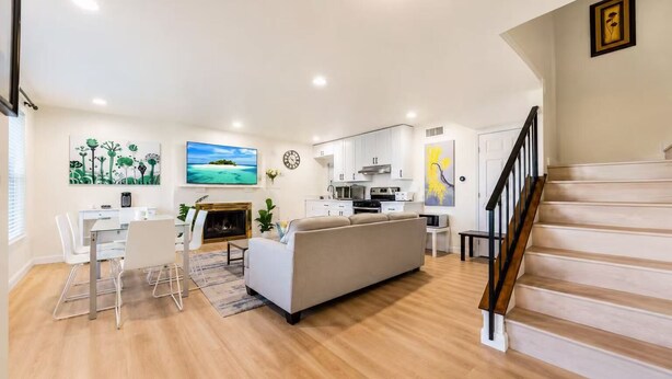 Un espacio habitable amplio con sofá, mesa de comedor y cocina al fondo.