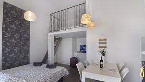 A bedroom with a bed, a desk, a chair, a staircase, and a television. - Modern Studio With Terrace (Umag)