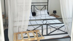 Een hemelbed met een baldakijn, een nachtkastje en een lamp.