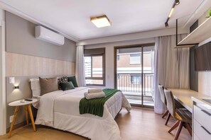 A modern hotel room with a bed, bedside table, and a balcony with a view. - Studio Completo a 5min do Nubank Parque | GP128 (Perdizes)