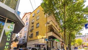 A multi-story building with a storefront labeled 'SKY' and a sign for 'ZAMBIBUTIK' on the ground floor. - Central Tirana 1BR Apartment Near Main Square by PikHost (Tiranë)