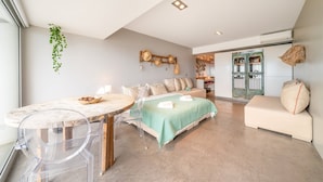 Un salon moderne avec une table à manger ronde, un canapé et un lit.