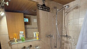Kylpyhuone, jossa on pesuallas, peili, suihku ja wc.