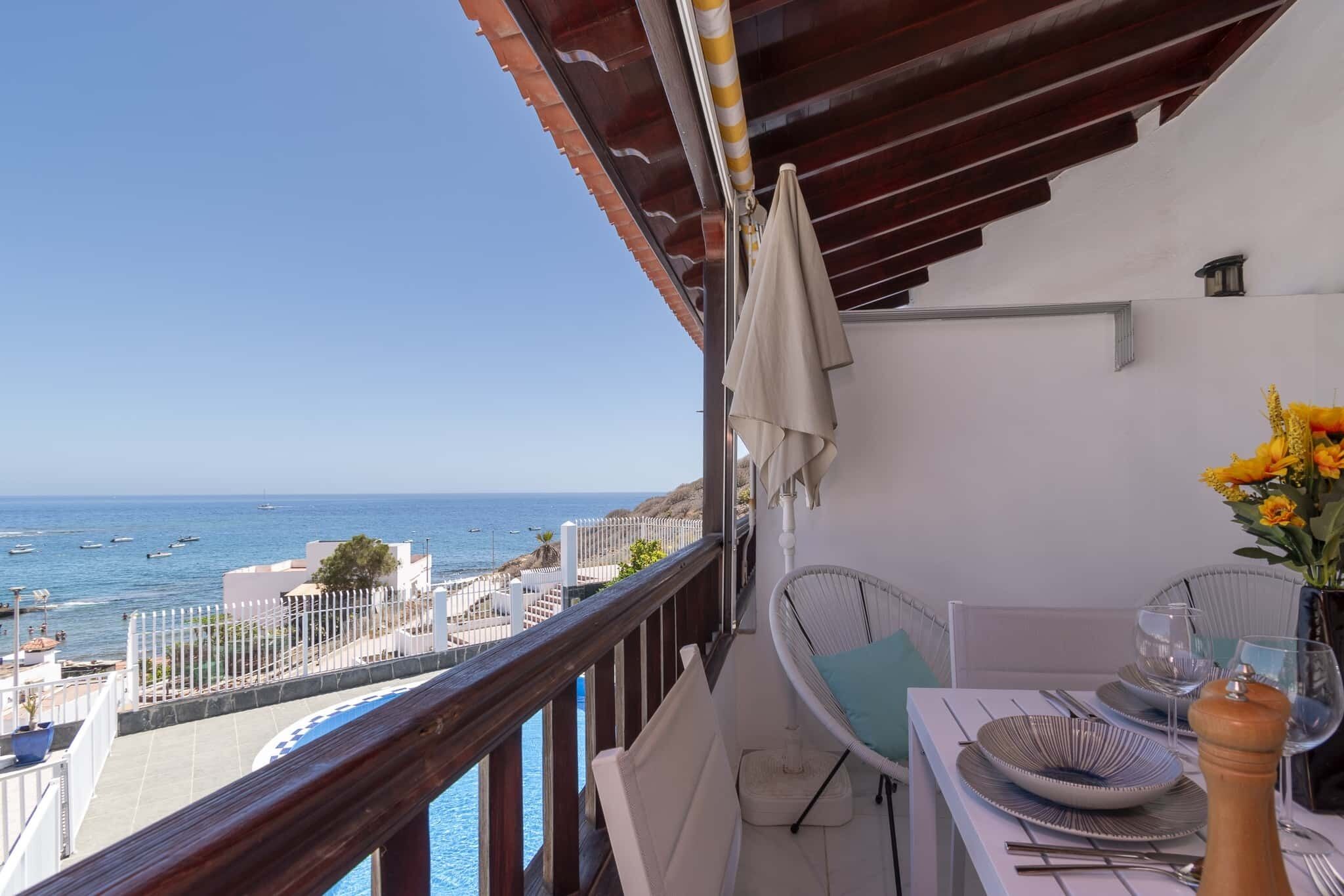 Ein Balkon mit Meerblick, ein Esstisch und ein Stuhl.