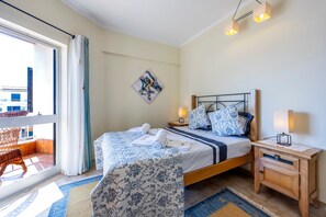 Quarto com cama, mesas de cabeceira, uma janela e vista para o exterior.