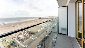 Un balcón con vista a la playa y al océano.