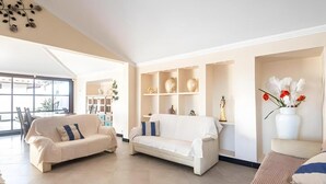 Ein geräumiges Wohnzimmer mit zwei Sofas, einem Couchtisch und einem Bücherregal.