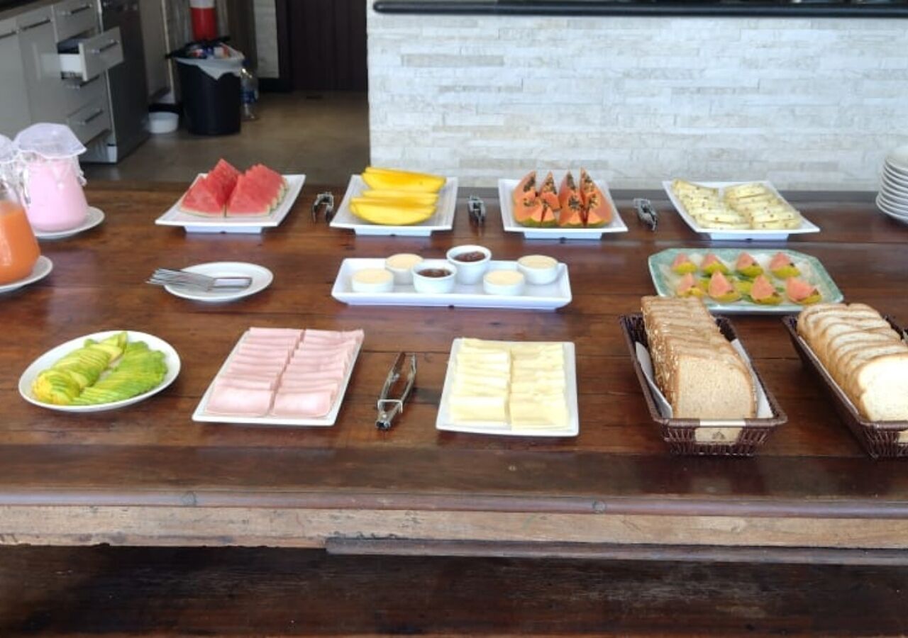 Un bufé con diferentes opciones de comida, incluyendo frutas, sándwiches y postres.