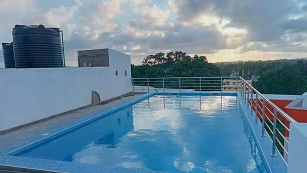 Ein Pool auf dem Dach mit freiem Blick auf die umliegenden Gebäude und Bäume.