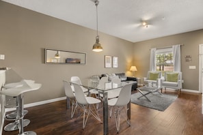 A modern living room with a dining area, a sofa, and a coffee table. - Modern Townhome 3 BD/ 2 BA/ West Lucaya (8980 SP) (Kissimmee)