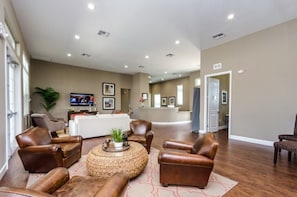 A spacious living area with leather sofas, a coffee table, and a television. - Modern Townhome 3 BD/ 2 BA/ West Lucaya (8980 SP) (Kissimmee)