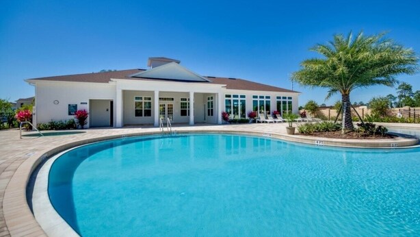 Un edificio moderno con piscina, un patio techado y una palmera.