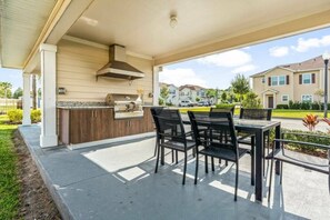 An outdoor patio with a grill and dining area, surrounded by a covered walkway. - Modern Townhome 3 BD/ 2 BA/ West Lucaya (8980 SP) (Kissimmee)