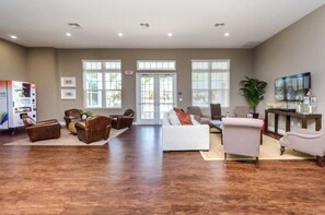 A spacious living area with a white sofa, brown leather chairs, a coffee table, and a television. - Modern Townhome 3 BD/ 2 BA/ West Lucaya (8980 SP) (Kissimmee)
