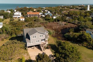 A residential area with houses, a lighthouse, and a body of water. - Springer's Retreat - Ocracoke Island (Ocracoke)