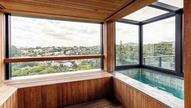 Ein Holzinnenraum mit einem großen Fenster mit Blick auf eine Stadtlandschaft.