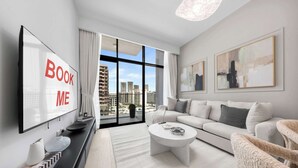 A modern living room with a sofa, coffee table, and artwork on the walls. - StayShort - Modern 1BR that Sleeps 4 at Riviera Beachfront (Meydan)