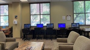 A conference room with multiple computer stations, chairs, and a coffee table. - Spacious 4-bedroom condo in peaceful Las Vegas with AC and gym (Las Vegas)