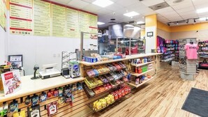 A grocery store interior with a checkout counter, snack shelves, and a menu board. - Spacious 4-bedroom condo in peaceful Las Vegas with AC and gym (Las Vegas)