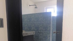 A bathroom with dark tiles, a shower, and a toilet. - Macumba Hotel and Restaurant The best view of the Ria Lagartos. (Río Lagartos)