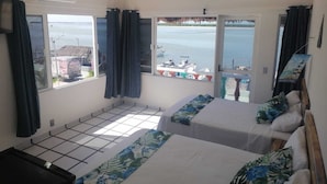 A hotel room with two beds, a ceiling fan, and a view of the sea. - Macumba Hotel and Restaurant The best view of the Ria Lagartos. (Río Lagartos)