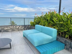 Ein blaues Sofa, ein kleiner Tisch und Blick auf das Meer.